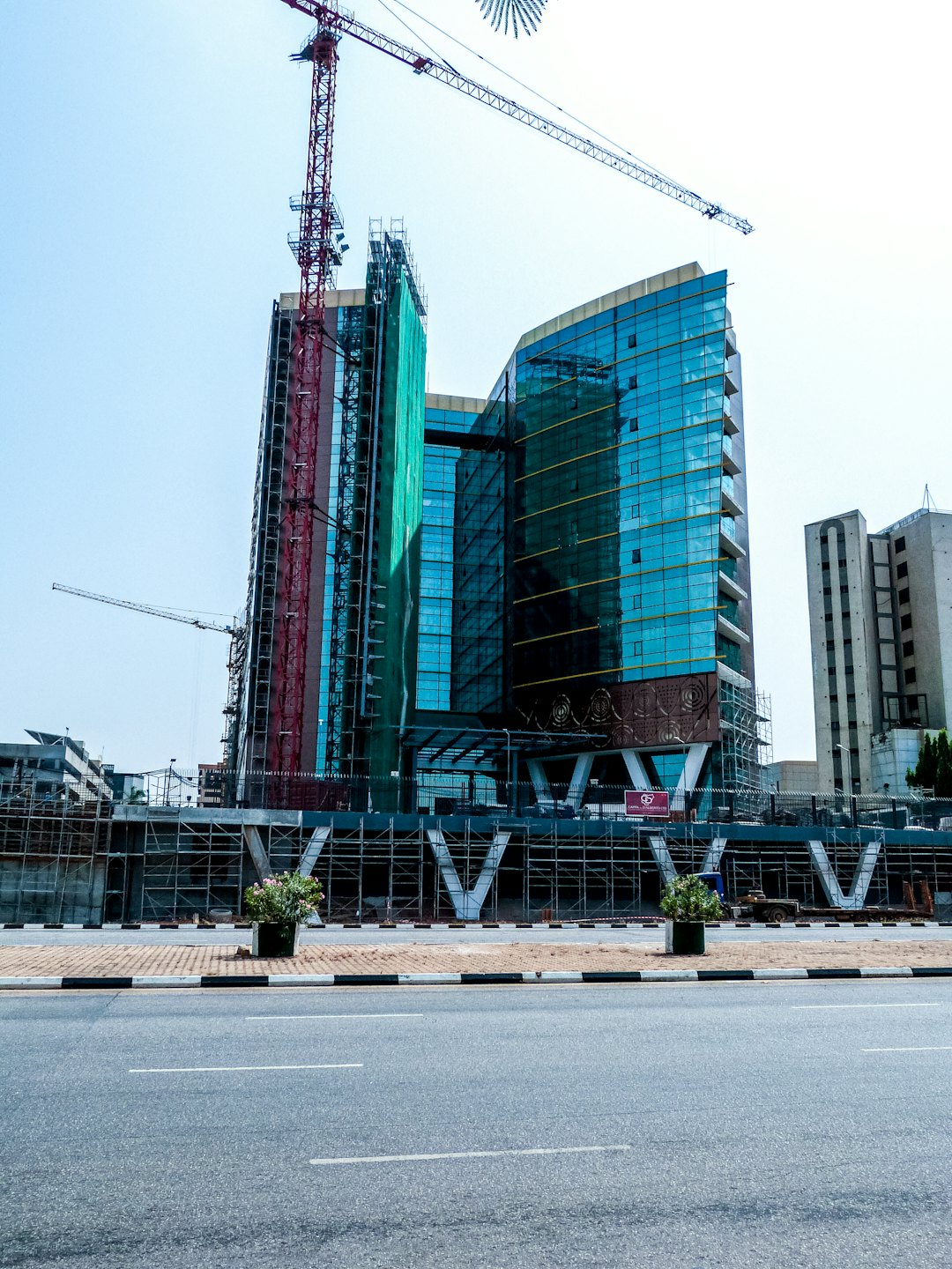 Moderne Baustelle mit Kränen vor blauem Himmel.